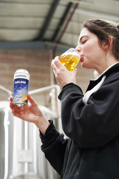 One of Cloudwater's brewers tasting a can of AGLOW West Coast IPA fresh off the canning line