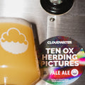 closeup of Cloudwater craft beer, pale ale 'Ten Ox Herding Pictures' poured from tap, bright orangey-yellow with the round keg badge situated next to it