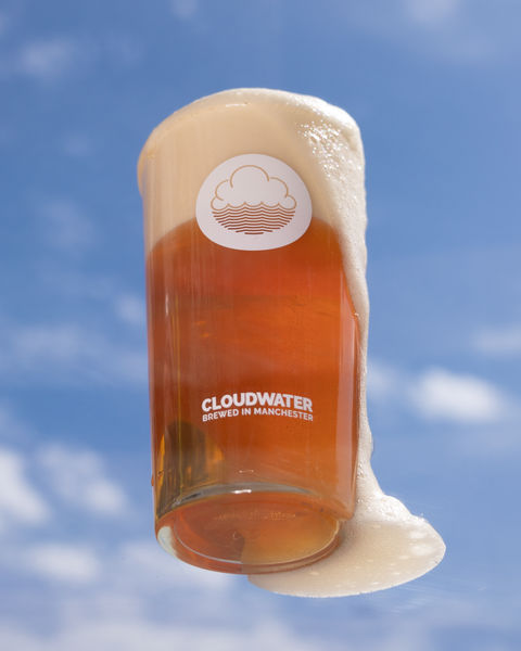 A crisp and clear pint of Drying Out Place West Coast Pale ale floats on a beautiful blue sky, foam pouring over the edge of the glass