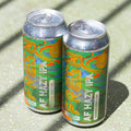 Two cans of Fresh AF IPA using Sabro hops sit on a sunny backdrop casting shadows across the vibrant cans
