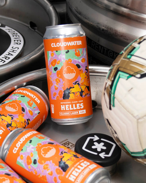 Bright orange patterned cans of Cloudwater lager rests ontop of silver kegs beside a football