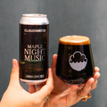 Person holding a Night Music Imperial Stout, Maple edition can with a Cloudwater branded Harmony glass with the delicious, delectable, delightful drink