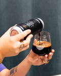 Person pouring a Night Music Imperial Stout, Maple edition from a can into a Cloudwater branded Harmony glass
