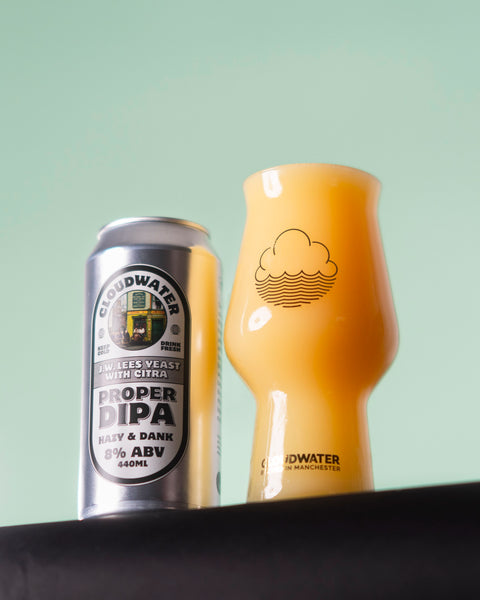 A silver can of Cloudwater Proper DIPA next to a matching Craftmaster glass full of the sweet, sticky and dank yellow-orange double IPA