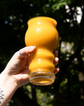 A hand holding a bright orange glass of delicious looking mango sour beer from Cloudwater Brewery. The sun is shining on the glass and it looks unbelievably summery