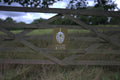 Hukins Hop farm in Kent, fence in a field with the Hukins Hop logo, a hop flower. Cloudwater Brew Co visited Hukins for their 2025 hop harvest and created a fresh hop beer with the Challenger variety