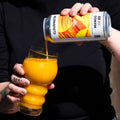 Person pouring Cloudwater Brewery Mango summer fruit sour beer into a glass