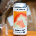 A can of Cloudwater Ultralight citrus table beer sits on a wooden surface with a blurred background.