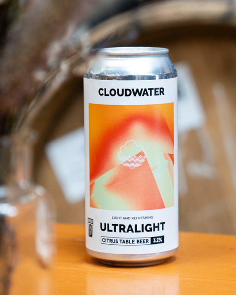 A can of Cloudwater Ultralight citrus table beer sits on a wooden surface with a blurred background.